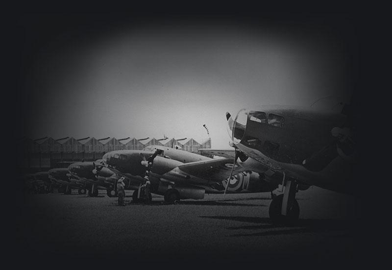 RAAF Lockheed Hudson bombers on an airfield. Aircraft hangar in the background.