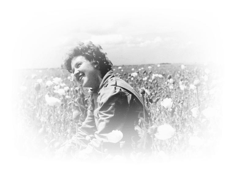 A woman smiling in a field of poppies. 