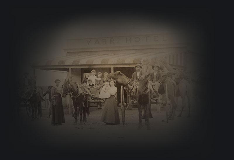 People, horses and carts gathered for a photo in front of a building