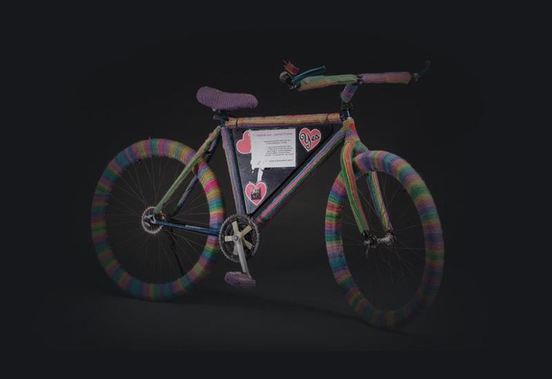 A push bike covered in rainbow crochet.