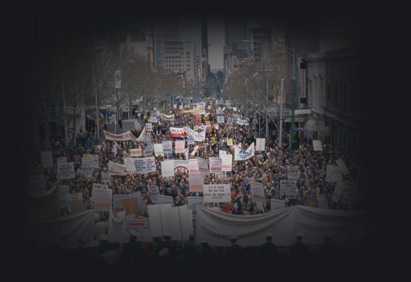 Protestors with placards fill a street in Melbourne.