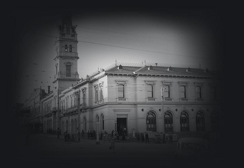 A large 2 story post office with ornate tower.