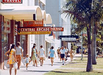 People in colourful clothing walk on the footpath adjacent to Central Arcade.