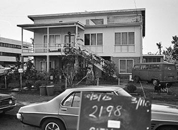 Parked cars and 3 storey house.