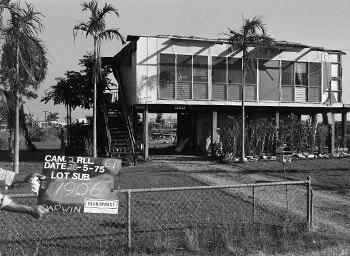 An land allotment sign infront of a damaged home.