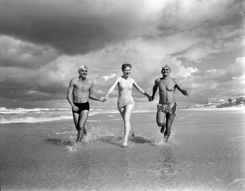 Two surf life savers and a woman on a Gold Coast beach.