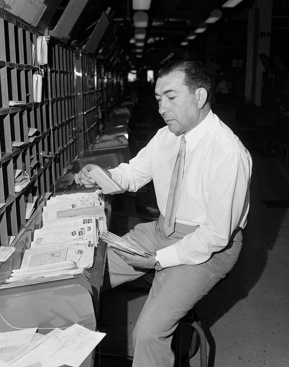 Migrant postal worker from Turkey, sorting mail in Sydney.