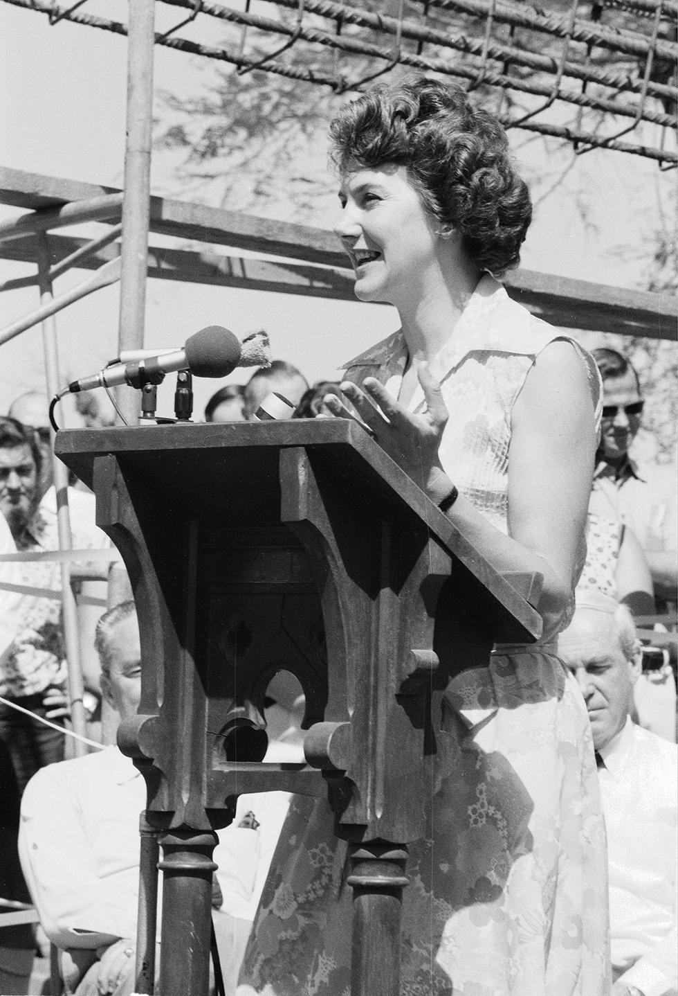 Tammy Fraser speaking from behind a lectern outside.