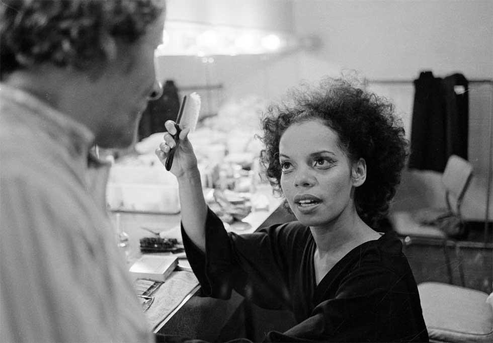 Roslyn Watson seated brushing her hair in her room at the Australian Dance Theatre.