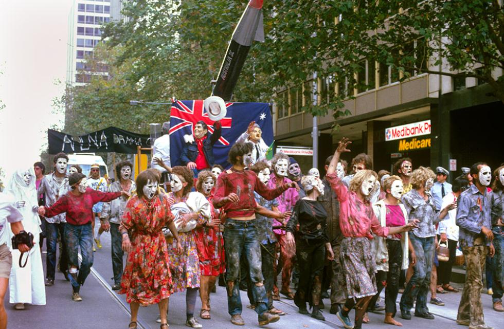 Protesters at a nuclear disarmament rally. They are wearing ragged clothes and have their faces painted white.