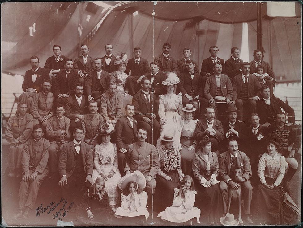 Smartly dressed circus troupe members, with children and two dogs.