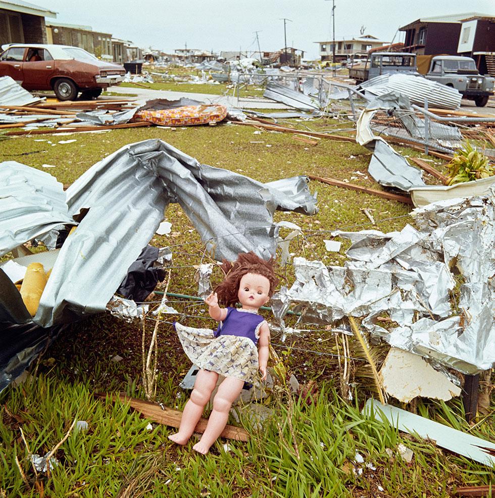 A doll amongst building material caught on a fence.