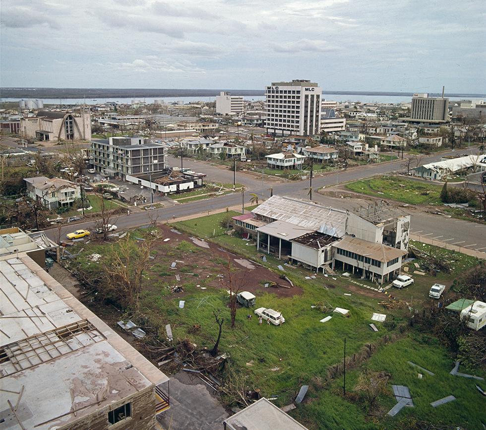 A few high-rise buildings appear relatively unscathed amongst damaged houses.