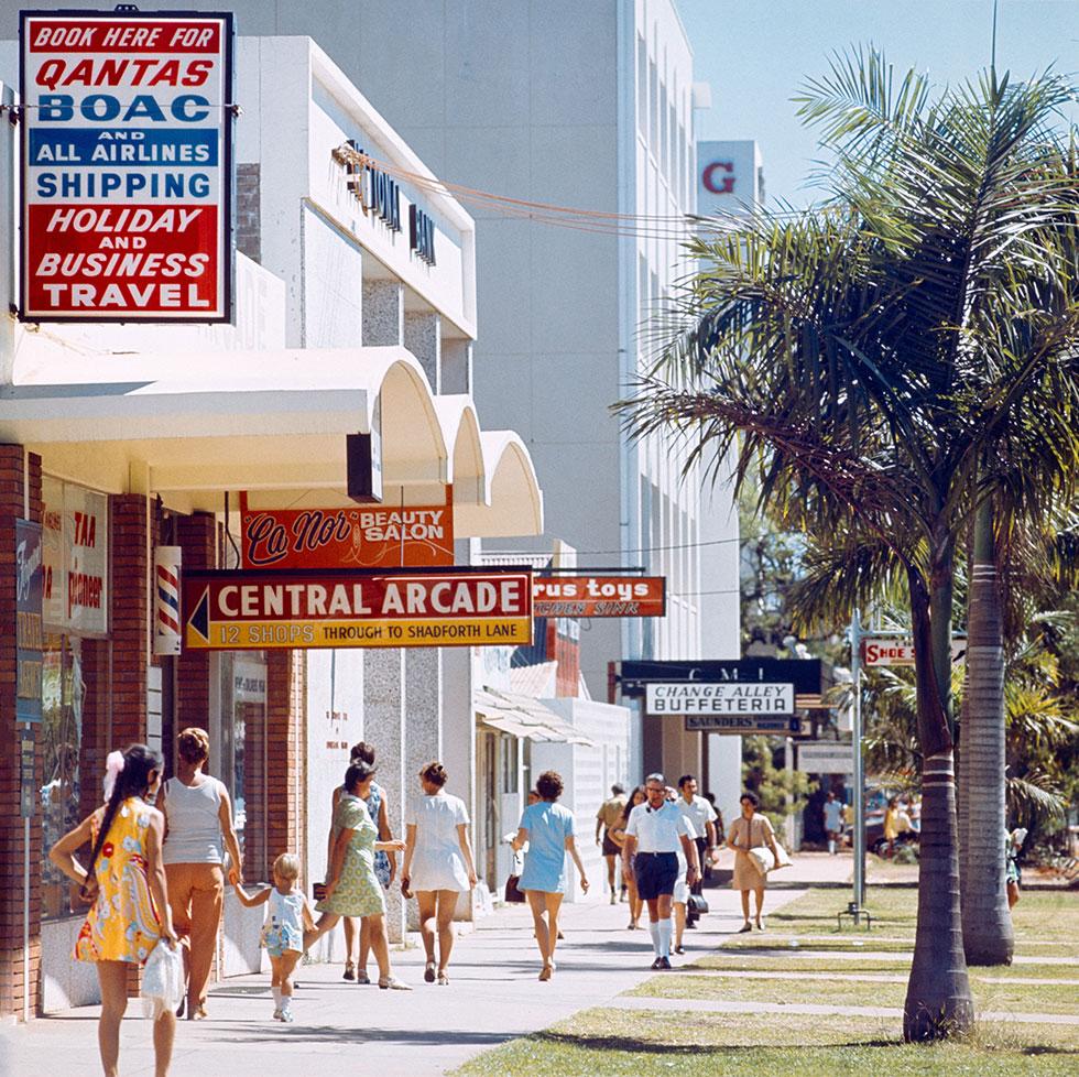 People in colourful clothing walk on the footpath adjacent to Central Arcade.