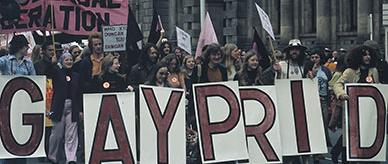 People with balloons and placards demonstrating on a city street.