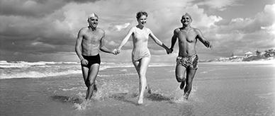 Two surf life savers and a woman on a Gold Coast beach.