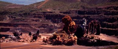 Detonating explosives at an open-cut mine. 