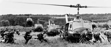 Australian troops departing from Iroquois helicopters in a field, Vietnam. 