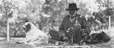 John Noble and his dog under a tree at the Bachelors Quarters in Acton, Canberra. 