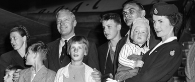 Otto Kampe and his family posing for a photo beside an airplane. 