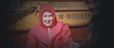 A woman in red waterproof clothing climbing down from a boat