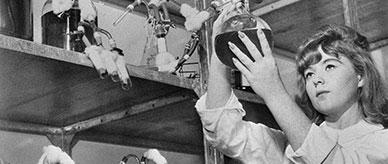 A woman working in a laboratory holding a glass tube that contains the antivenom for snake bites manufactured at CSL.