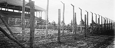 Grandstand seating behind a barbed wire fence.