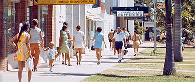 People in colourful clothing walk on the footpath adjacent to Central Arcade.