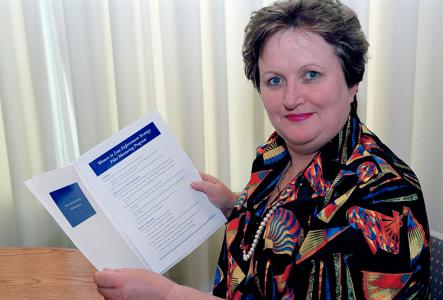 Amanda Vanstone, Minister for Justice and Customs, holding a copy of the Women in Law Enforcement Strategy