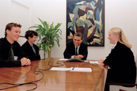 Deputy Prime Minister John Anderson with three Rotary students seated at a polished timber table. Indoor plant and artwork in the background.