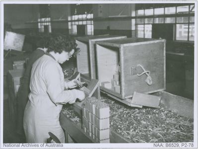 A female munitions worker packs cartridges, 1945. NAA: B6529, P2-78 