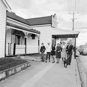 6 members of the Hoogenhout family walking down a footpath with their arms linked. 