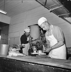 Jan Hoogenhout ices a cake inside his bakery. 