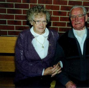 Nieske and Jan Hoogenhout sitting on a bench with their arms linked.