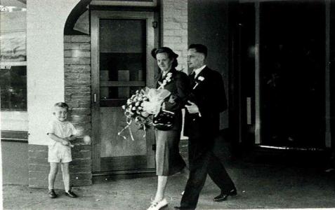 Nieske and Jan Hoogenhout walking out of a building dressed in their wedding clothes. 