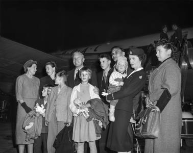 Otto Kampe and his family standing for a photo in front of an aeroplane.