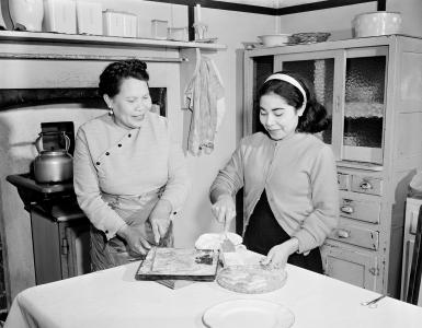 Annie and her daughter Mary in her kitchen, preparing food. 