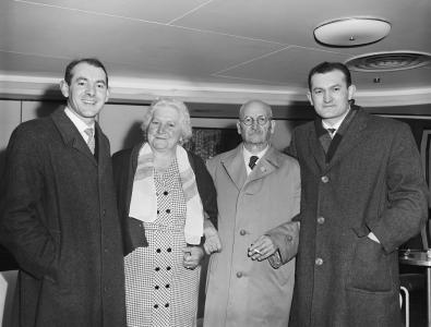 Two men standing with their older parents.