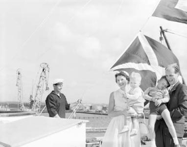 Adriana and her husband holding their two sons on the deck of a ship. 