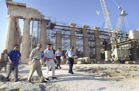 Prime Minister Howard and others outside the Acropolis, which is covered in scaffolding. 