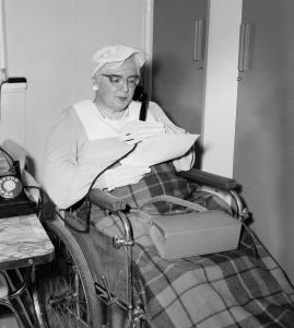 Doris Taylor, sitting in her wheelchair with a checked wool blanket beside a telephone.