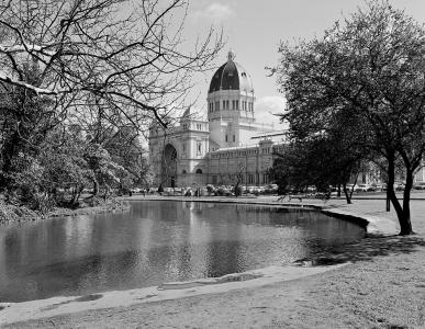 Melbourne's domed Royal Exhibition building framed by trees and an ornamental lake.