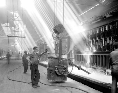 Light filtering through to workers standing on a factory floor.