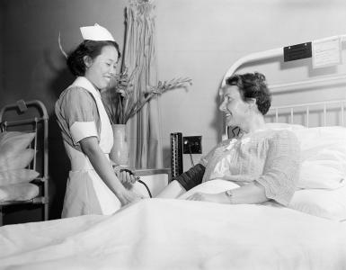 A nurse standing beside a patient.