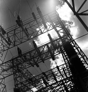 Bright backlit clouds framed by an electrical substation.