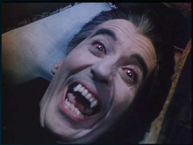 Vampire reclined in a coffin with fangs bared and bloodshot eyes.