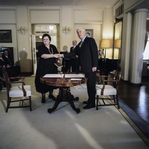 Amanda Vanstone and Governor-General Michael Jeffery shaking hands over a table with signed documents.