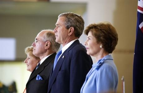 John and Janette Howard and George and Laura Bush standing in front of an Australian flag.