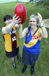 Labor MPs Anna Burke and Nicola Roxon in football uniforms, holding up a red football. 