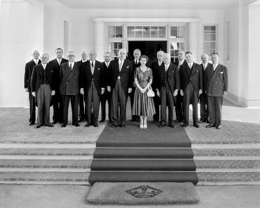 Queen Elizabeth II, Prime Minister Menzies and Federal Cabinet members assembled above steps at the entrance to the Governor-General's residence.